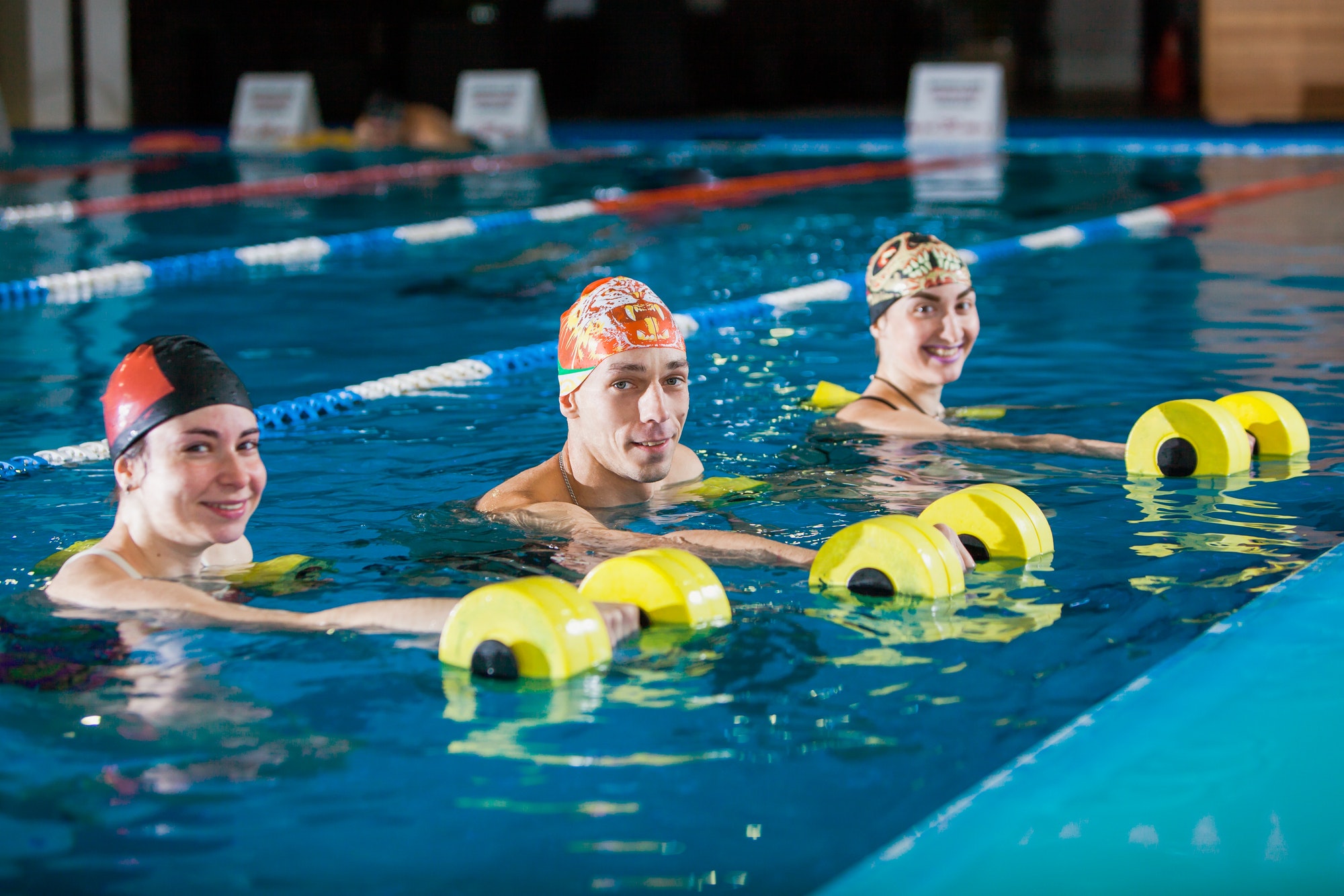 Group of happy people on aqua fitness in swimming pool.